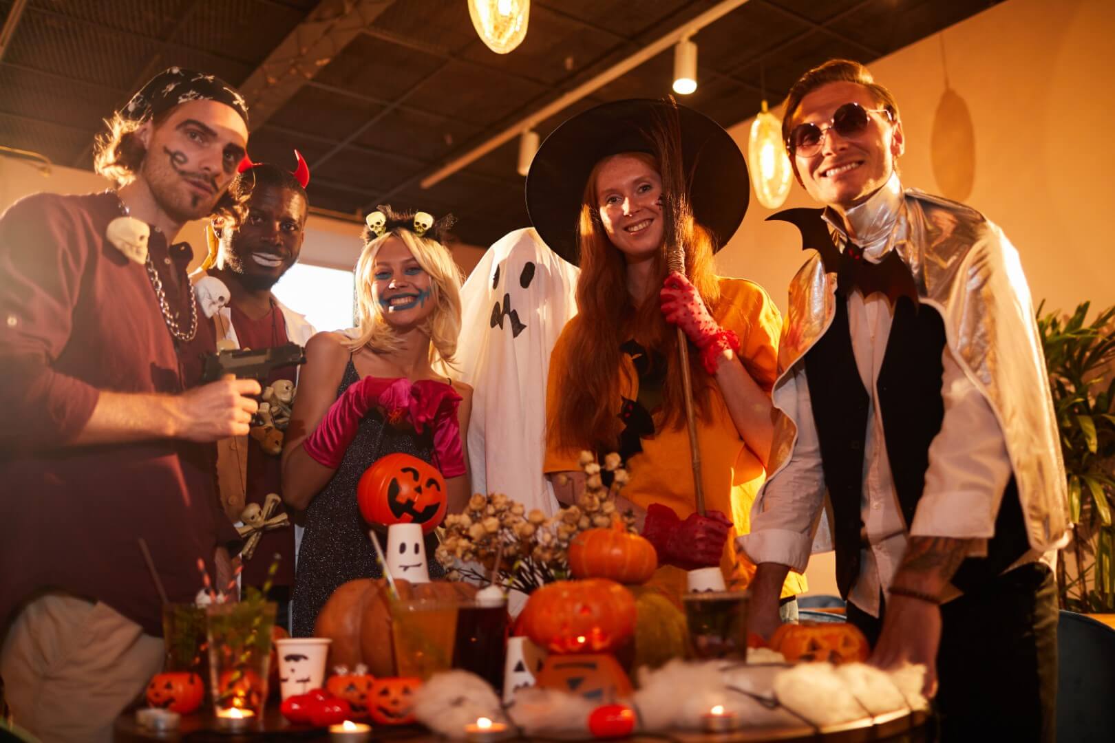 Portrait of adult people wearing Halloween costumes posing making faces at camera during party in nightclub, copy space